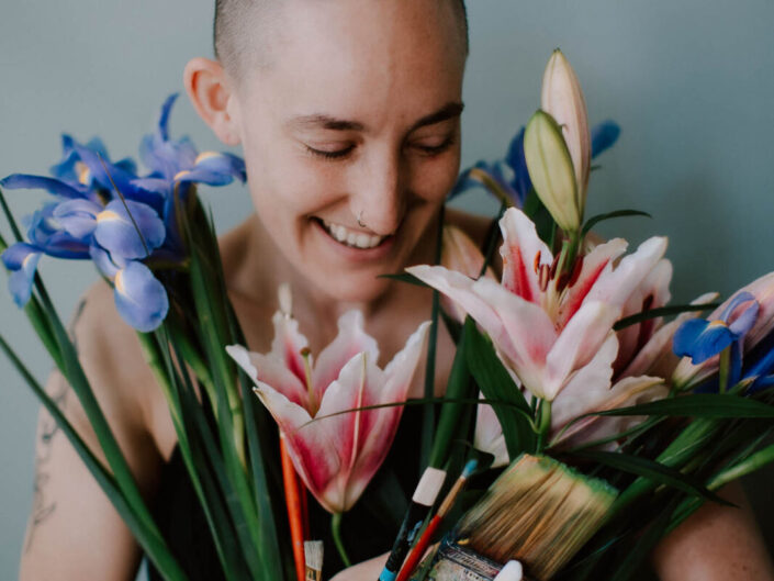 artist with flowers and paint brushes