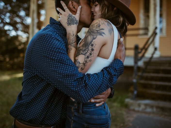 woman with tattoos kissing man